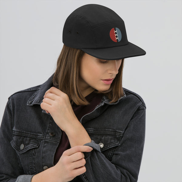 Witness Mended Signal cap worn facing forward, showing the rust-red and blue embroidered split circle with cream stitches.